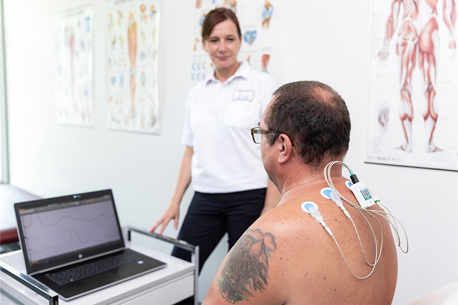 Eine Mitarbeiterin der Klinik betreut einen Patienten bei der Biofeedback-Therapie. Eine Mitarbeiterin der Klinik betreut einen Patienten bei der Biofeedback-Therapie.